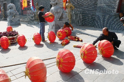 8月31日，河南省開(kāi)封市天波楊府門口，工作人員在準(zhǔn)備懸掛大紅燈籠。隨著“十一”國(guó)慶節(jié)和“十一”旅游黃金周的臨近，古城開(kāi)封的公園景點(diǎn)已早早開(kāi)始備戰(zhàn)，營(yíng)造喜慶祥和的旅游環(huán)境，迎接八方客人。 中新社發(fā) 李俊生 攝