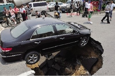 4日，南昌市昌南大道與迎賓北大道交叉口附近路面突然發(fā)生塌陷，一輛過路小轎車被卡在洞口處。圖/新華社