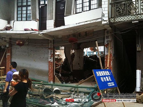 大成橋鎮(zhèn)老街，16號門面，房梁垮塌、房屋變形，門前的卷閘門已是一邊高一邊低。 圖/瀟湘晨報滾動新聞記者 劉剛