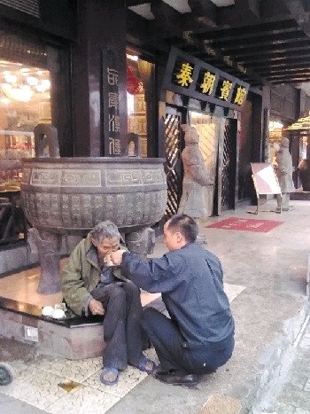 8月25日，網(wǎng)友申超在街頭拍下的張副山喂老人吃面一幕。 