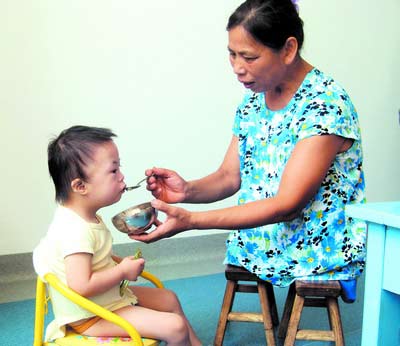 許月華在給孩子喂飯。劉炬 攝