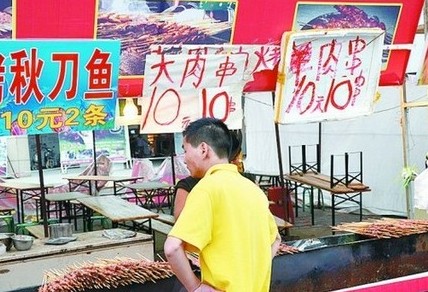 被查后，美食街上的'羊肉串'的'羊'字被涂抹了。
