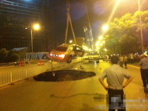 吊車將墜入塌陷坑的汽車吊出。圖/末代小王爺