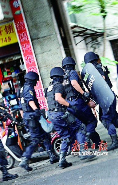 特警將嫌疑人（紅圈內(nèi)）押上警車。