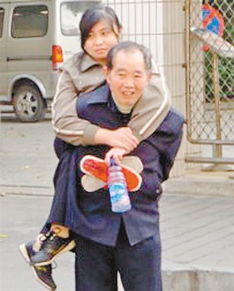 邱世祿背小娟上學(xué)。