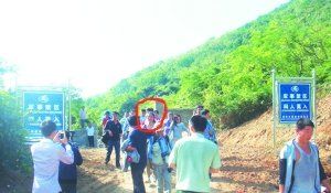 被困女子（圈中）獲救后從山嶺入口處豎有“軍事禁區(qū)”的標牌旁通過。