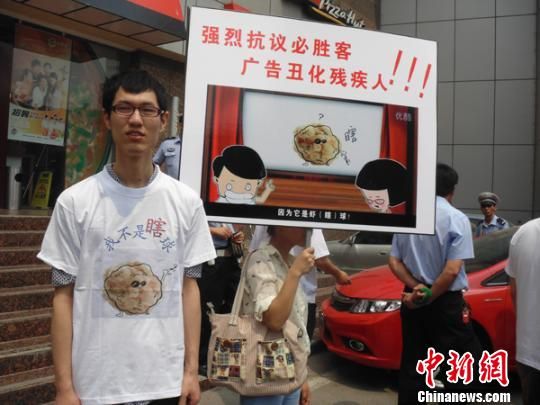 6月5日，視障人士在鄭州一必勝客門前舉牌抗議蝦球廣告歧視。 門杰丹 攝
